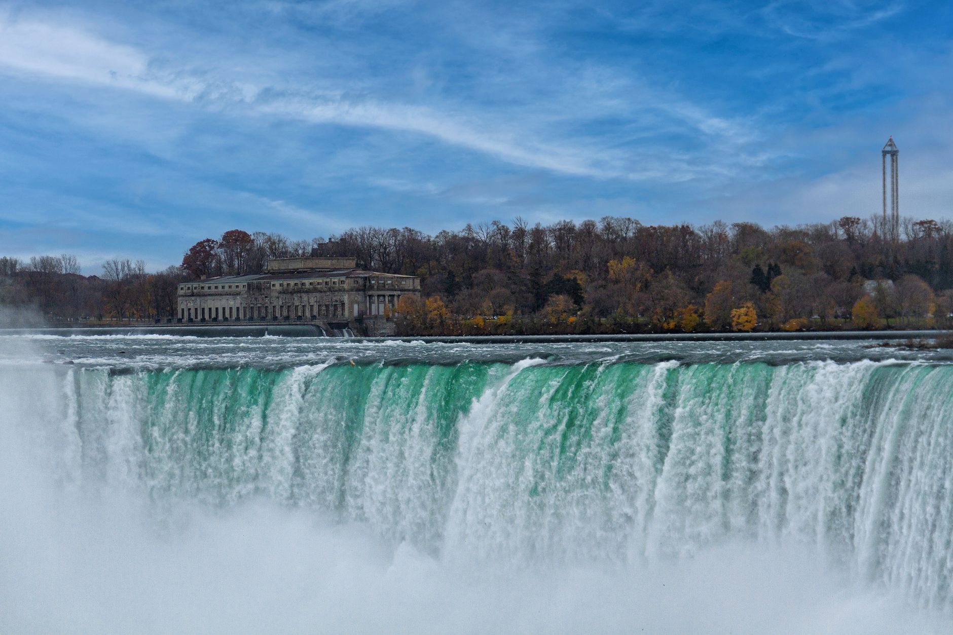 building on shore by waterfall