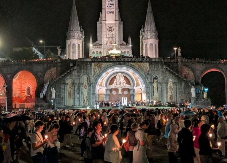 Lourdes Torchlight Procession gathering in front of the Basilica at night